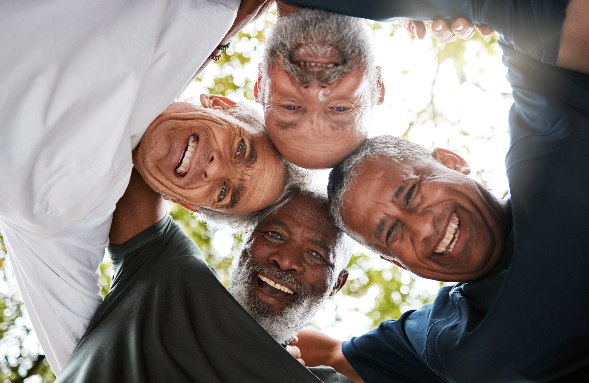 Senior men, friends and community together in a circle for support, trust and diversity with a smil